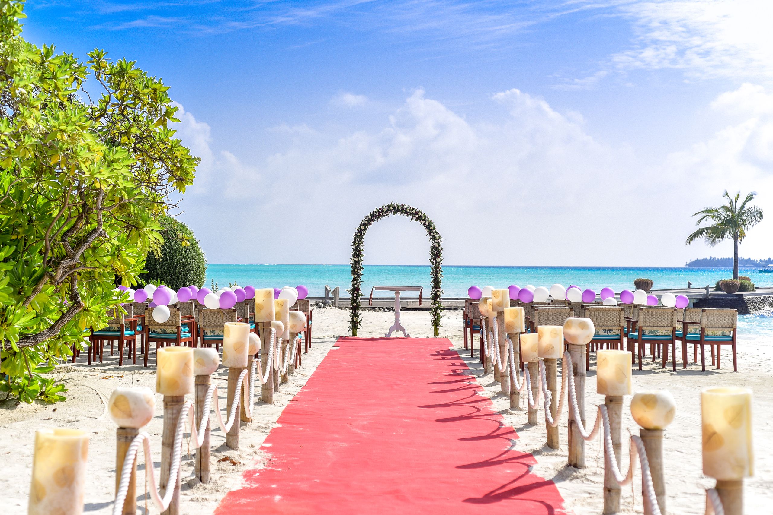 Beach wedding with floral arch by the lagoon